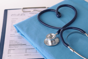 A stethoscope shaping a heart on a medical uniform, closeup