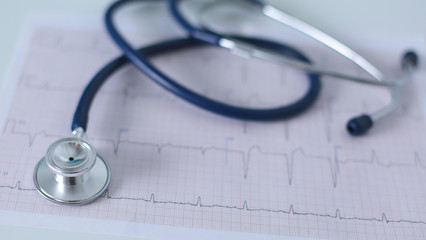 Stethoscope on cardiogram concept for heart care on the desk.blue toned images