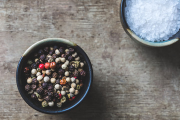 Top view of spice, red pepper and coarse salt, in ceramic bowls on an old, rustic wooden background, vintage toned