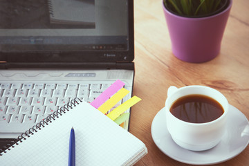 office working desk top view with laptop, notepad and coffee