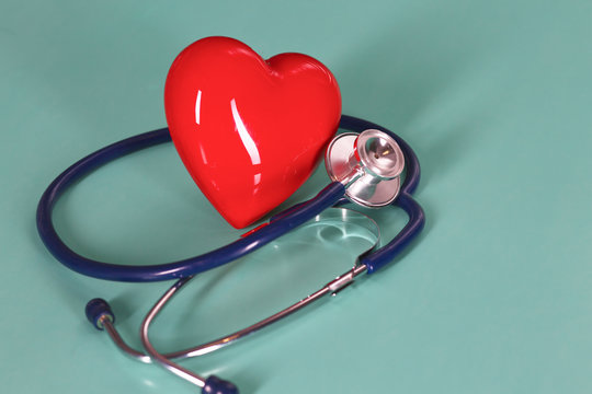 Red heart with stethoscope on blue wooden background. Copy space. Valentines day.