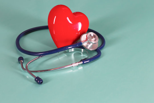 Red heart with stethoscope on blue wooden background. Copy space. Valentines day.