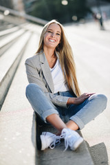 Fototapeta na wymiar Beautiful young blonde woman smiling on urban steps.