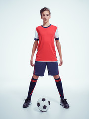Photo of teen boy in sportswear holding soccer ball