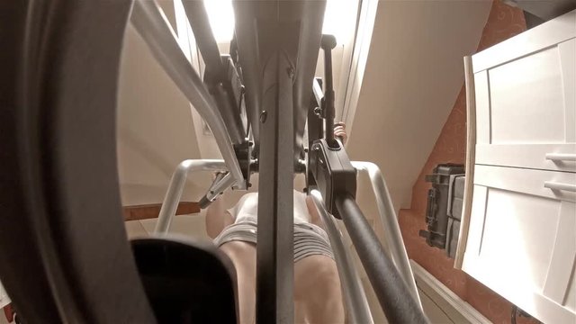 Close up view on legs of man exercising on crosstrainer machine
