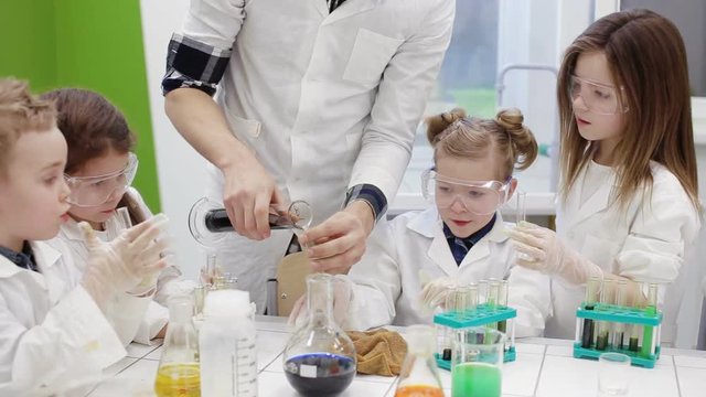 Teacher helps students in the chemistry class