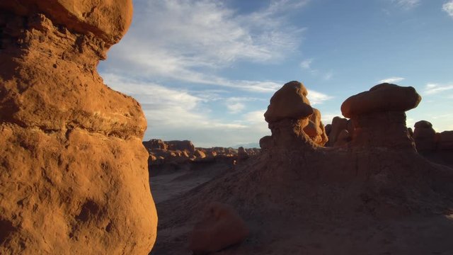 Walking through the hoodoos in Goblin Valley at sunset as the rocks glow.
