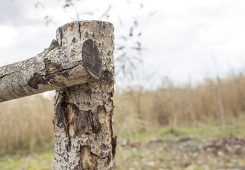 Wooden fence near the river. connection of beams