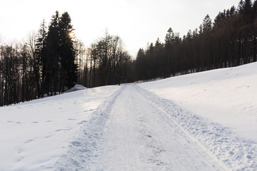 Photo of snowy landscape with blue sky and road in winter