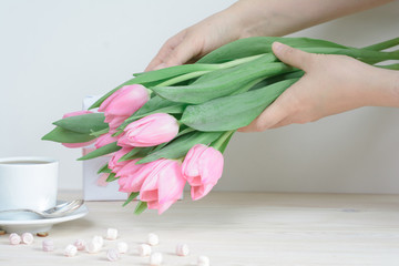 Woman's hands holding pink tulips
