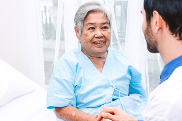 Obraz premium Doctor holding elderly person hand with care in hospital.healthcare and medicine