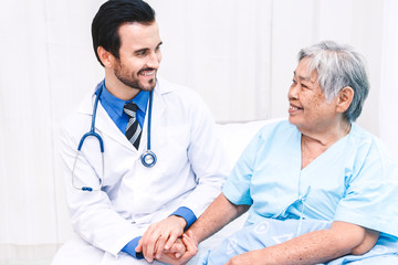 Doctor holding elderly person hand with care in hospital.healthcare and medicine