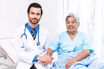 Doctor holding elderly person hand with care in hospital.healthcare and medicine