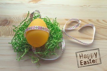 yellow egg in braid on wooden background