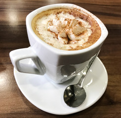 Cup of cappuccino served on table