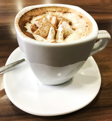 Cup of cappuccino served on table