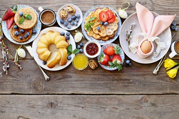 Easter dessert table. Pancakes,waffles and bundt cake with fresh berries and various of topping. Overhead view, copy space