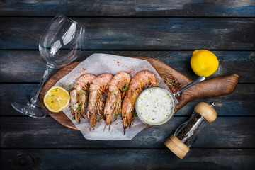 Grilled shrimp or langoustine with white sauce and lemon.