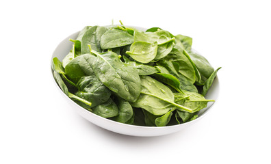 Spinach. Fresh baby spinach leaves in plate isolated on white