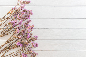 dried flowers on white wooden planks background