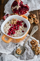 Tasty homemade Breakfast: oatmeal with pomegranate and nuts on natural wooden background rustic. The concept of a healthy diet, a high-carbon Breakfast.