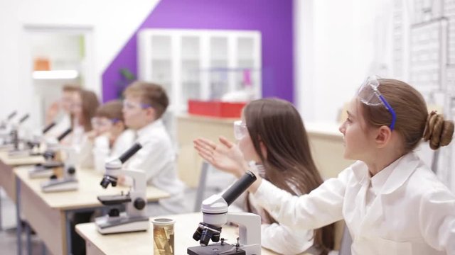 Children at school looking into microscope