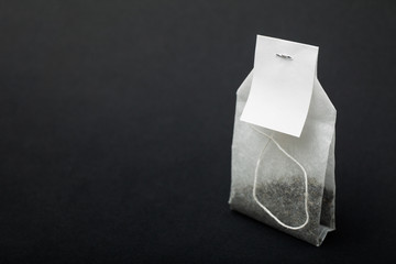 A mockup organic tea in a paper bag on a black background.
