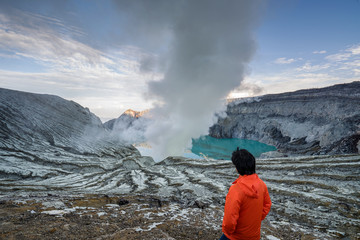 Young travler looking crater blue lake at Kawah Ijen, Indonesia
