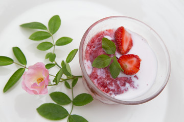 Strawberry milk and rose on wood table