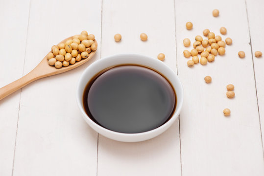 Soy sauce and soy bean on wooden table