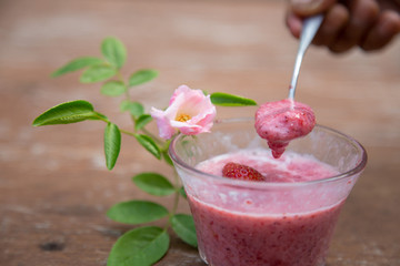 Strawberry milk and rose on wood table