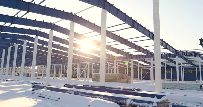 Construction of a modern factory or warehouse, modern industrial exterior, panoramic view, Modern storehouse construction site, the structural steel structure of a new commercial building