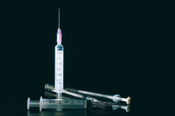 Medical syringe on the dark.