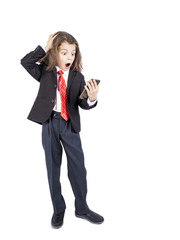 Portrait of a little Caucasian boy holding a two-handed phone with a crazy shocked look and an open mouth in surprise