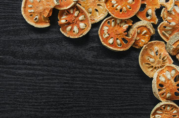 Dried herbs and dried bael fruit, Top view of bael dry on the wooden floor, Slices of bael fruit for make bael juice on the dark table.