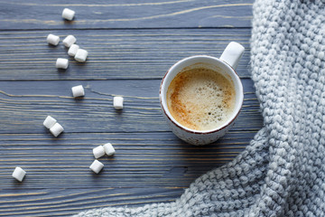 Cup of coffee with marshmallow on a wooden background.