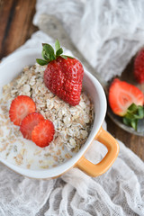 Breakfast: granola with berries fresh strawberries on wooden background natural rustic. The concept of healthy eating.