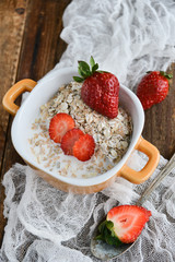 Breakfast: granola with berries fresh strawberries on wooden background natural rustic. The concept of healthy eating.