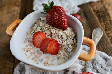 Breakfast: granola with berries fresh strawberries on wooden background natural rustic. The concept of healthy eating.