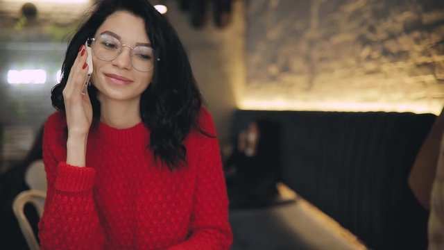 Woman in red clohes talking by phone in cafe