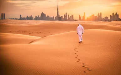 Crédence de cuisine en verre imprimé Dubai Homme arabe avec des vêtements traditionnels des émirats marchant dans le désert