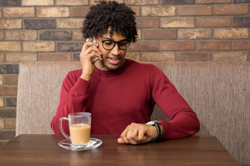 Fototapeta na wymiar Handsome young businessman talking on the phone at a cafe