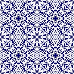 Seamless pattern with ethnic ornaments with curls. White floral pattern on a blue background.