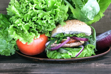 A meat burger, vegetables and salad.