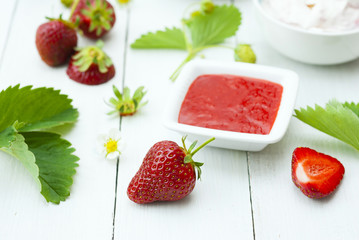 strawberry fruits with jam and whipped cream dessert on white wood table background