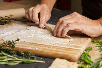 Woman's hands rolling up dough.