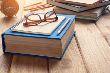 Books and glasses on a wooden table desk