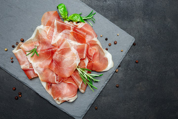 Italian prosciutto crudo or spanish jamon. Raw ham on stone cutting board