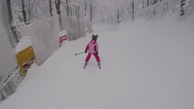 A little girl skiing in mountains