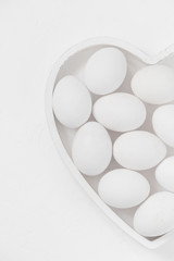 Fototapeta na wymiar White eggs background Easter heart